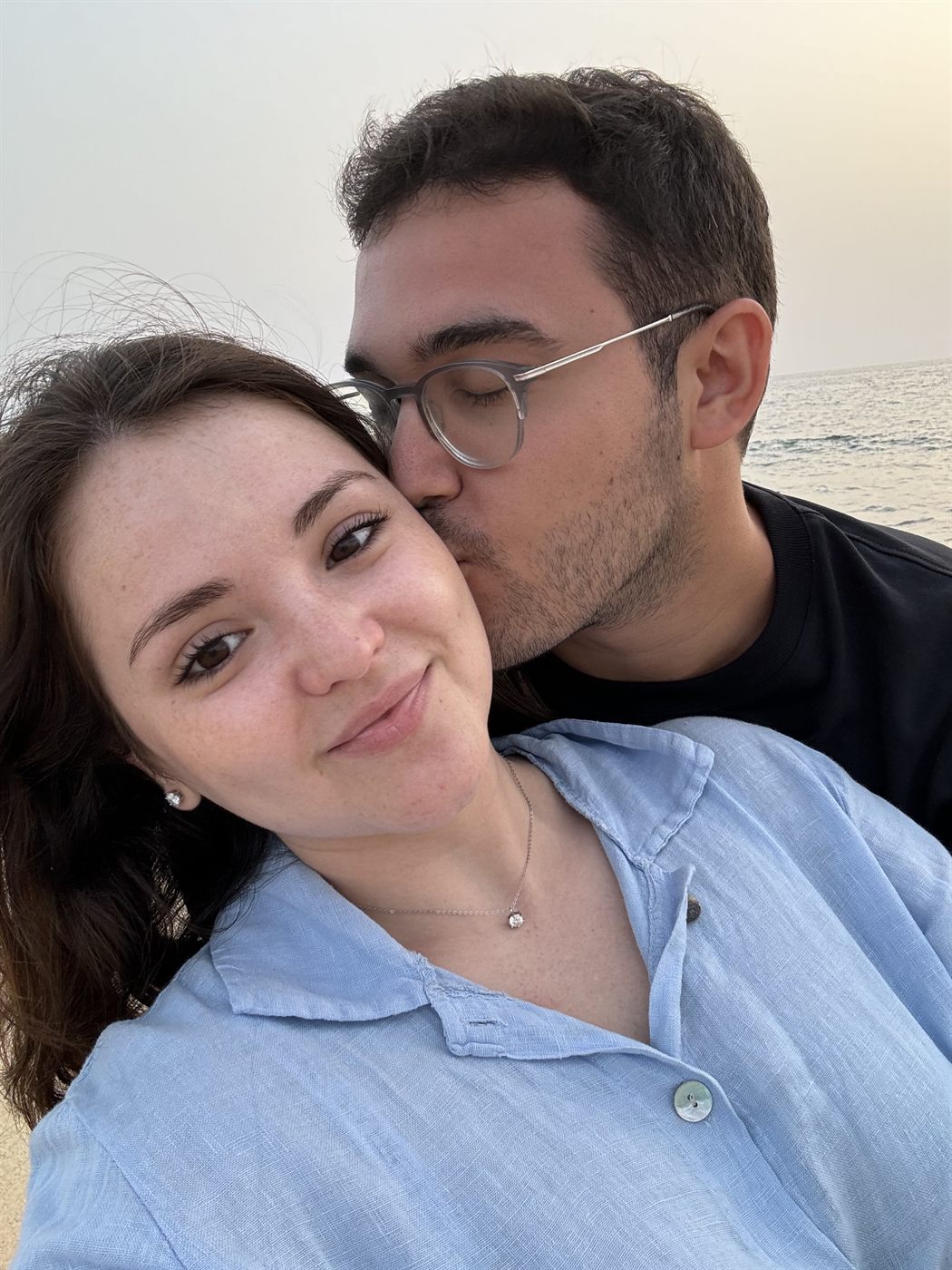 Los dos muy cerca, mirando a la cámara, con el mar detrás