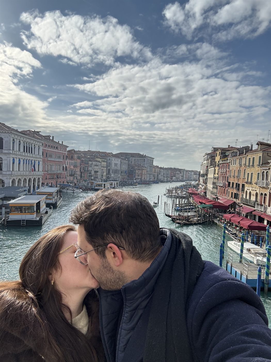 Los dos besándose en el puente de Rialto, con el Gran Canal de Venecia detrás